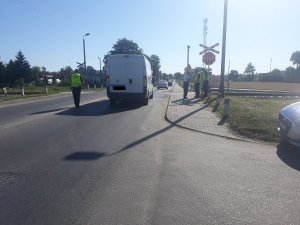 policjanci i funkcjonariusz sop-u rozdaja kierowcom ulotki
