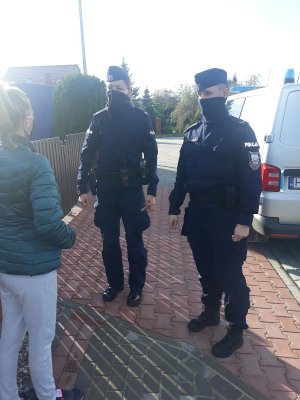 policjanci na chodniku rozmawiają z kobietą