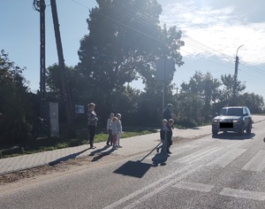 policjant przechodzi z dziecmi przez przejście