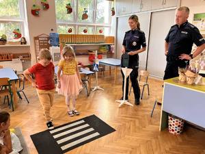 policjanci pokazuja dzieciom sygnalizacje świetlną