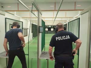 dwóch policjantów stoi na stanowiskach i przygotowuja się do strzelania