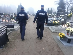 policjanci poruszający sie po cmentarzu