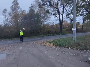 policjant na drodze daje znak do zatrzymania pojazdu