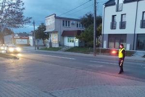 policjant na drodze daje znak latarka do zatrzymania pojazdu